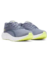Championes de running Under Armour Ascend color gris, con parte superior de malla transpirable, entresuela Charged+ Cushioning blanca con detalles salpicados, suela de goma con detalles en verde lima y el logo de la marca en el talón.