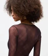 Body de tul negro con transparencia, manga larga y escote en V profundo con detalle de encaje en el borde. Presenta un diseño ajustado al cuerpo con cierre de broches a presión en la parte inferior.