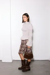 Camisa blanca de broderie con cuello alto, cuerpo y puños con frunces elásticos, y mangas largas abullonadas.