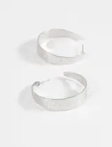 Par de caravanas plateadas con diseño de argolla ancha y textura martillada.