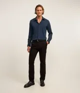 Pantalón de vestir negro de corte slim, confeccionado en tejido de sarga de algodón y elastano.