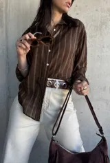 Camisa marrón a rayas verticales blancas, de corte holgado y manga larga.