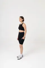 Calza corta de lycra negra, estilo biker, con cintura alta y bolsillos laterales.