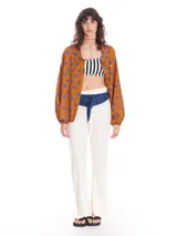 Pantalón de lino color crudo, de corte recto, con cintura alta y cierre frontal con botón y cremallera.