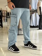 Pantalón cargo de jean azul claro, con corte oversize y múltiples bolsillos laterales en las piernas.