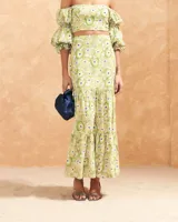 Blusa corta con estampado floral en tonos amarillo y verde, escote bardot, mangas abullonadas 3/4 con puños elásticos y espalda elastizada.