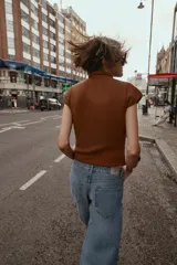 Top de tejido de punto color marrón óxido, manga corta y cuello mao con cierre frontal de botones.