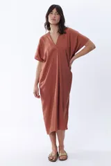 Vestido midi color canela de corte amplio, con escote en V y mangas cortas.