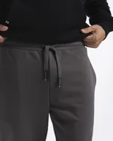Pantalon de jogging de felpa color gris, con cintura elástica ajustable mediante cordón y puños elásticos en los tobillos.