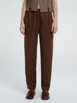 Pantalón de corte recto y tiro medio, color marrón, con cintura elástica y cordón ajustable.