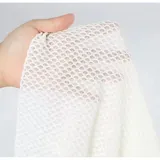 Conjunto de baño de cuatro piezas en color negro, confeccionado en tejido de malla transparente. Incluye un top de bikini triangular, una remera manga larga abierta con lazo frontal para anudar, y una pollera corta ajustable con cordones laterales.