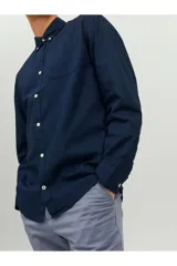 Camisa de manga larga azul marino, con cuello abotonado, cierre con botones blancos y bolsillo de parche en el pecho. Corte slim fit. Marca Jack & Jones.