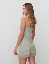 Chemise corta negra de seda fría, marca Montelle, con breteles finos regulables y apliques de encaje en el escote en V y el ruedo.