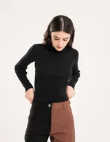 Polera negra de tejido de punto acanalado, con cuello alto y mangas largas.