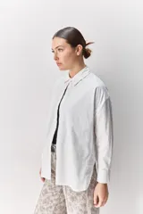 Camisa de algodón de calce relajado con cuello clásico, mangas largas con puños abotonados y cierre frontal con botones.