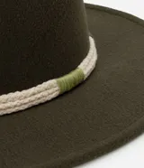 Sombrero de fieltro color verde oliva, con ala corta y copa moldeada. Decorado con cordón trenzado en tonos crudo y verde.