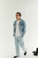 Campera de jean celeste claro con cuello clásico, cierre frontal con botones metálicos, bolsillos con solapa abotonada en el pecho y bolsillos laterales.