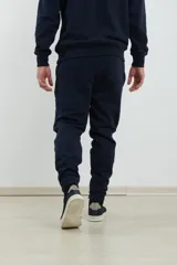 Pantalón jogging de corte ajustado, con cintura elástica y puños elastizados en los tobillos. Presenta un diseño minimalista en color gris oscuro, ideal para un look urbano y deportivo.