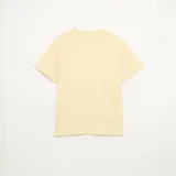 Remera lisa de corte holgado, color amarillo claro, con mangas corta y cuello redondo.