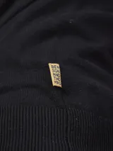 Sweater negro de punto con cuello polo y mangas largas.