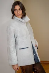 Campera reversible de cuero ovino con interior de piel sintética, diseño oversize, cierre frontal con broches y bolsillos laterales.