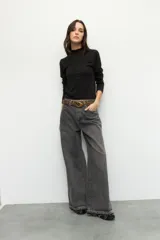 Polera blanca de manga larga con cuello alto y costuras cruzadas a la vista en el frente.