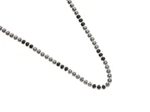 Collar de diseño minimalista compuesto por una alternancia de pequeñas cuentas de piedra natural negra y esferas metálicas de acero.