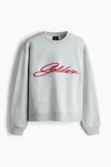 Buzo de cuello redondo en tejido de algodón gris melange, con diseño de hombros caídos y bordado frontal con la palabra 'Golden' en color rojo. Presenta puños y bajo acanalados.