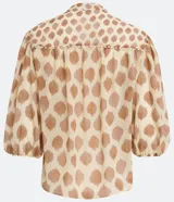 Camisa de gasa color beige con estampado de lunares marrones, cuello mao, mangas 3/4 abullonadas y cierre frontal con botones.