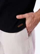 Remera polo de manga corta en tejido cloqué color gris, con cuello camisero y cierre frontal de botones.