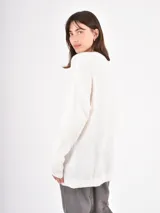 Buzo de tejido de punto con cuello en V, manga larga y diseño holgado.