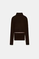 Jersey de punto liso confeccionado en 100% lana, con cuello subido y manga larga. Incluye un cinturón fino integrado en la cintura con hebilla metálica.