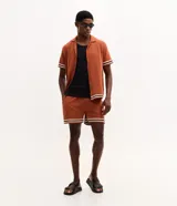 Bermuda masculina de jacquard color marrón tostado, con cintura elástica, bolsillos y detalle de franjas blancas en los dobladillos.