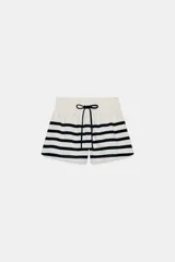 Shorts de tiro alto y cintura elástica ajustable con cordones a contraste, con bolsillos laterales ocultos en la costura.