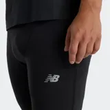 Calza deportiva ajustada negra, de tiro medio, con cordón de ajuste en la cintura elástica y logo reflectante de New Balance en el muslo.