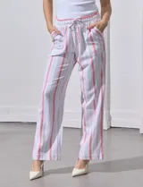 Pantalón de lino de la marca Marissa Olivia, con pretina ancha elastizada y lazo de ajuste. Diseño a rayas verticales en blanco, rojo y azul. Cuenta con bolsillos inclinados en la parte delantera.