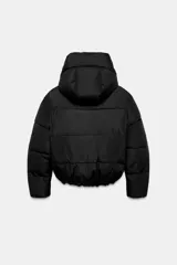 Campera puffer acolchada de color negro, con cuello envolvente, capucha integrada, manga larga, bolsillos laterales ocultos y bajo con elástico. Cierre frontal con botones a presión ocultos por solapa.