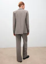 Pantalón gris de tiro medio, con diseño recto y largo, confeccionado en mezcla de lana con forro interior y cierre de cremallera lateral.