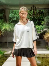 Pollera corta negra de gabardina, estilo plisado, con tiro medio y bordado frontal.