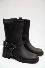 Botas de caña media en eco cuero negro con acabado mate, tacón bajo y una correa con hebilla y tachas plateadas alrededor del tobillo.