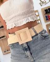 Cinturón ancho de rafia trenzada color crudo con hebilla cuadrada grande del mismo material.