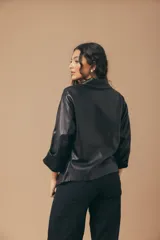 Camisa de cuero color fucsia, de corte recto, con cuello clásico y cierre frontal con botones.