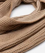 Bufanda beige de punto grueso con efecto melange y flecos en los bordes.