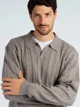 Sweater tipo polo de punto con diseño de trenzas, color azul marino, con cuello clásico y abertura frontal.