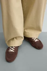 Zapatilla de estilo retro con cordones, confeccionada en una combinación de piezas de tela y cuero con acabado de gamuza. Cuenta con suela dentada en contraste.