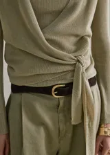 Cardigan cruzado de punto fino en color verde militar, con cuello en V, manga larga y cierre de lazo lateral.