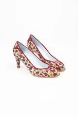 Zapatos de salón de tacón medio, confeccionados en arpillera con estampado multicolor en tonos marrones, granates y ocres. Presentan un diseño estructurado con piezas diferenciadas en puntera, laterales y talonera, unidas por ribetes de terciopelo granate. Cuentan con interior en piel y suela de cuero.