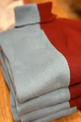 Polera de acrílico de dos colores, azul claro y bordó, con cuello alto.