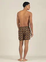 Short de baño con estampado floral en tonos marrones y amarillos, con cordón ajustable en la cintura, bolsillos laterales y trasero con cierre, y suspensor de malla fina hipoalergénico.