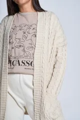 Cárdigan negro tejido con diseño de ochos, corte holgado y bolsillos frontales.